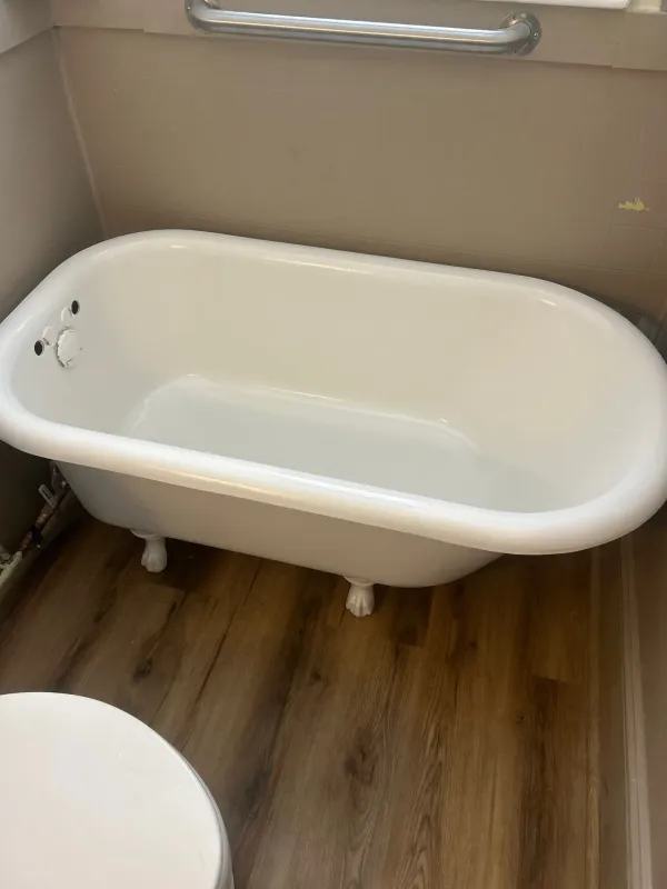 Clawfoot tub after reglazing installed in bathroom with clean white finish