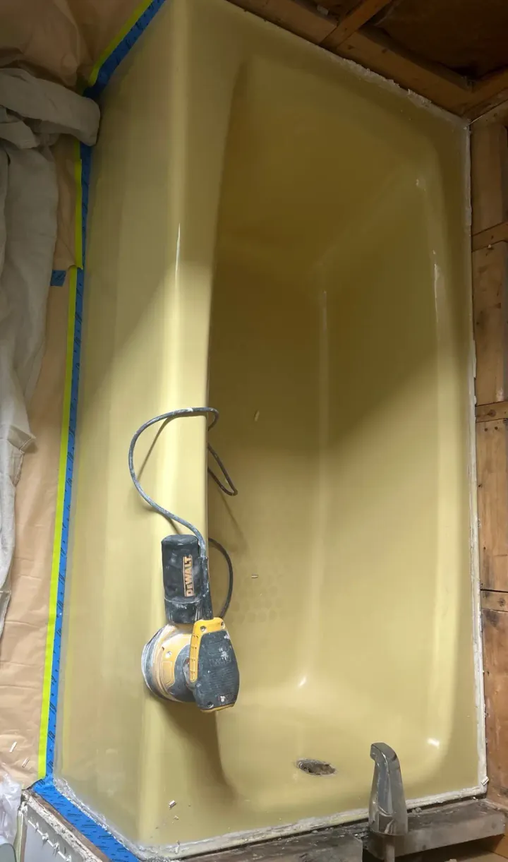 Worn yellow bathtub before reglazing